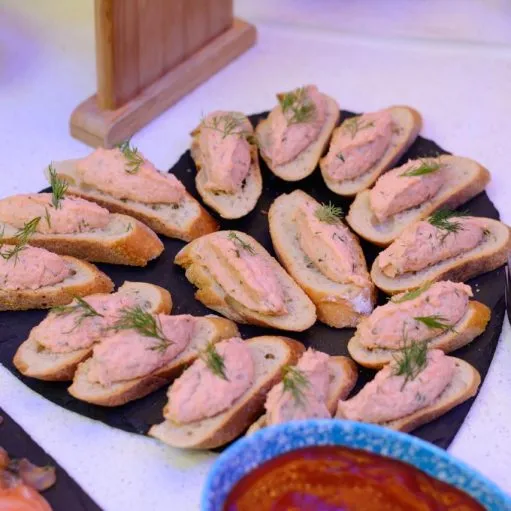Toasts garnis de rillettes de saumon et aneth disposés sur une ardoise
