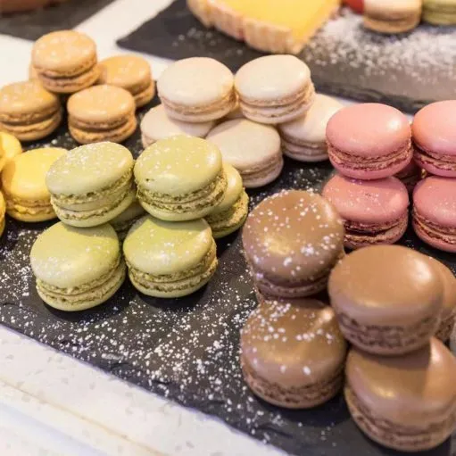 Macarons de plusieurs parfums disposés sur des ardoises du buffet desserts