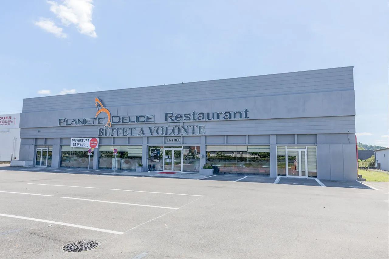 Façade du restaurant Planète Délice et son parking gratuit
